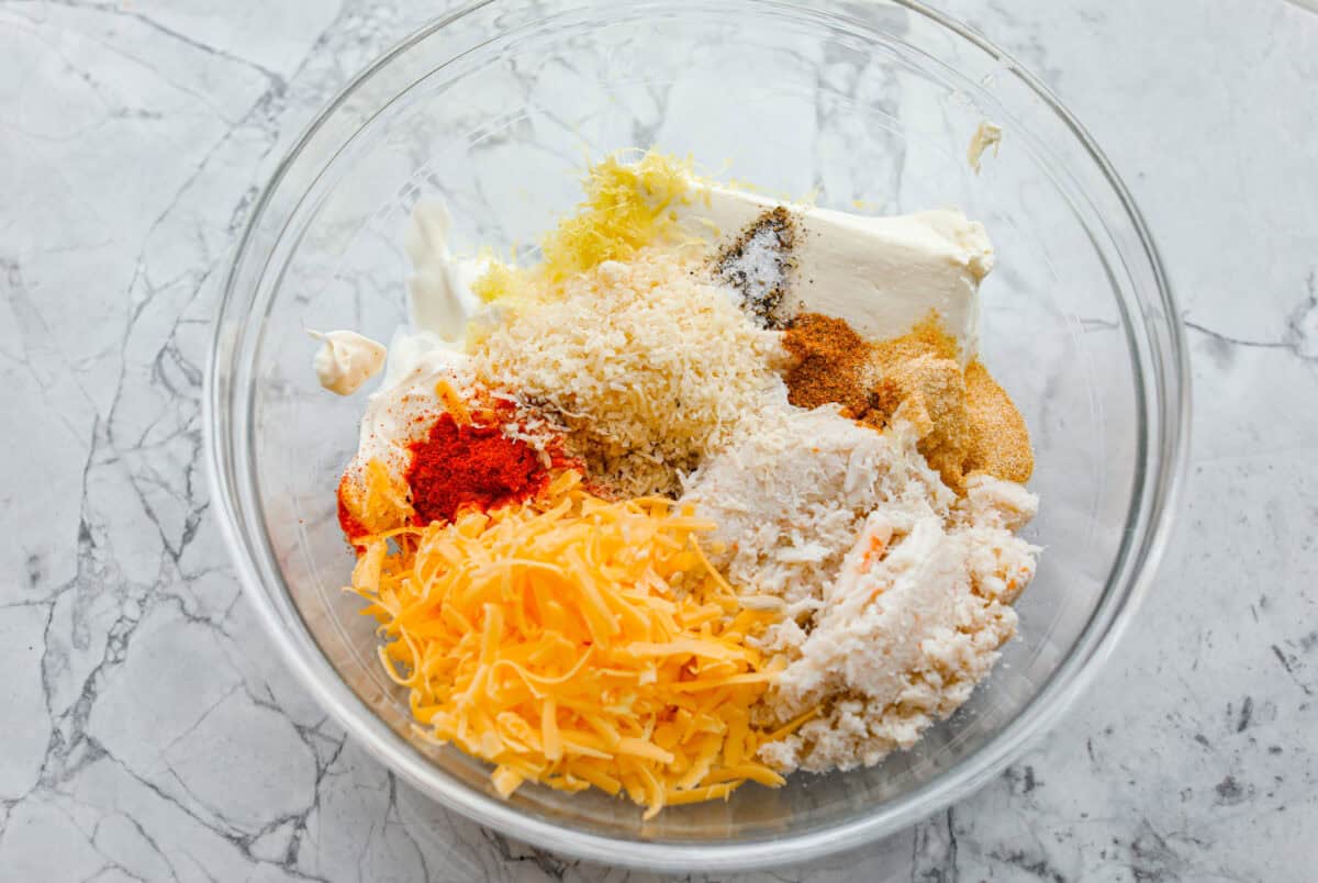 My hot crab dip is one of those recipes you have to try. It’s creamy, cheesy, and irresistible. Ready in about 30 minutes, it’s my go-to when I want something that feels fancy but takes zero effort. All of the ingredients added to a mixing bowl.
