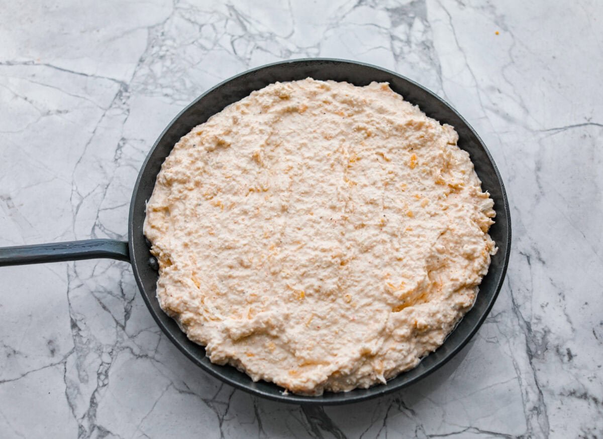 My hot crab dip is one of those recipes you have to try. It’s creamy, cheesy, and irresistible. Ready in about 30 minutes, it’s my go-to when I want something that feels fancy but takes zero effort. All of the ingredients mixed together then added to a cast iron skillet.