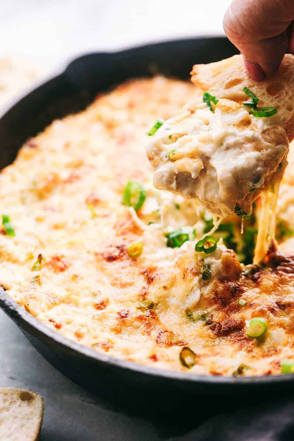 My hot crab dip is one of those recipes you have to try. It’s creamy, cheesy, and irresistible. Ready in about 30 minutes, it’s my go-to when I want something that feels fancy but takes zero effort. Hot Crab Dip in a metal pan. There is piece of bread dipping into the pan.