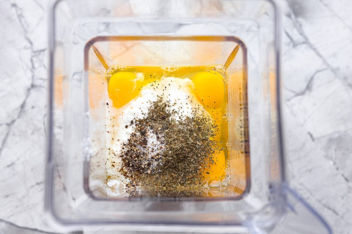 In a blender, add the eggs, cottage cheese, salt, pepper, and dried basil. Eggs, cottage cheese, and seasonings inside a blender.