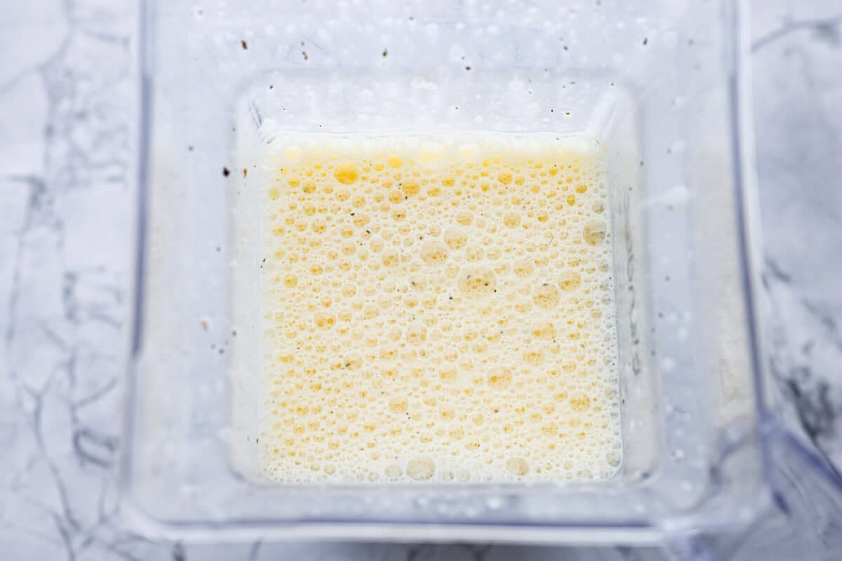 In a blender, add the eggs, cottage cheese, salt, pepper, and dried basil. Ingredients all blended up in the blender.