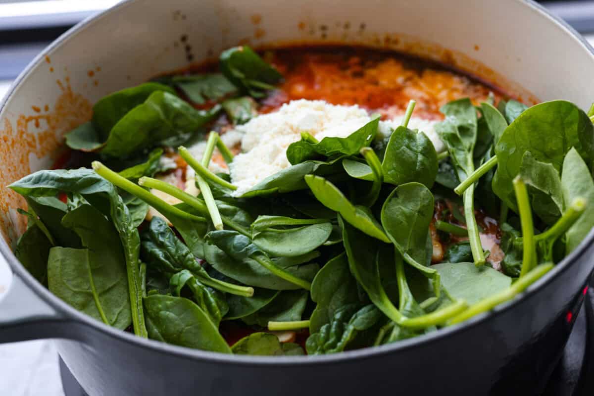 Million Dollar Soup is creamy, comforting, and worth every indulgent bite! The rich tomato soup base is loaded with sausage, cheesy ravioli, and heavy cream. The dollop of ricotta cheese on top is a MUST! Spinach, ravioli, cream and parmesan added to the pot.