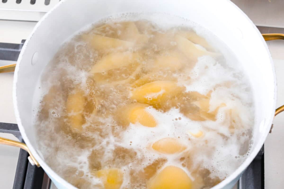 Jumbo pasta shells boiling in a large pot. 