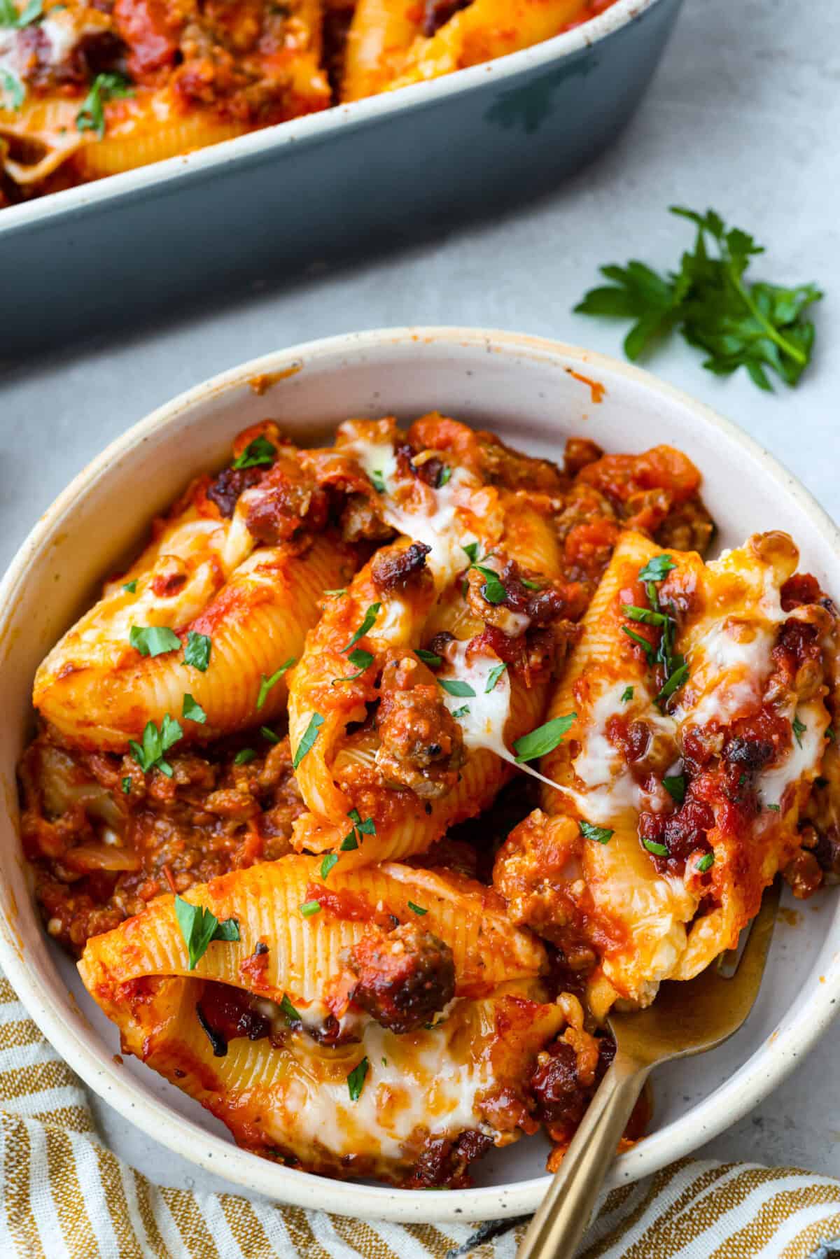 Plated serving of million dollar stuffed pasta with a gold fork and garnished with parsley. 