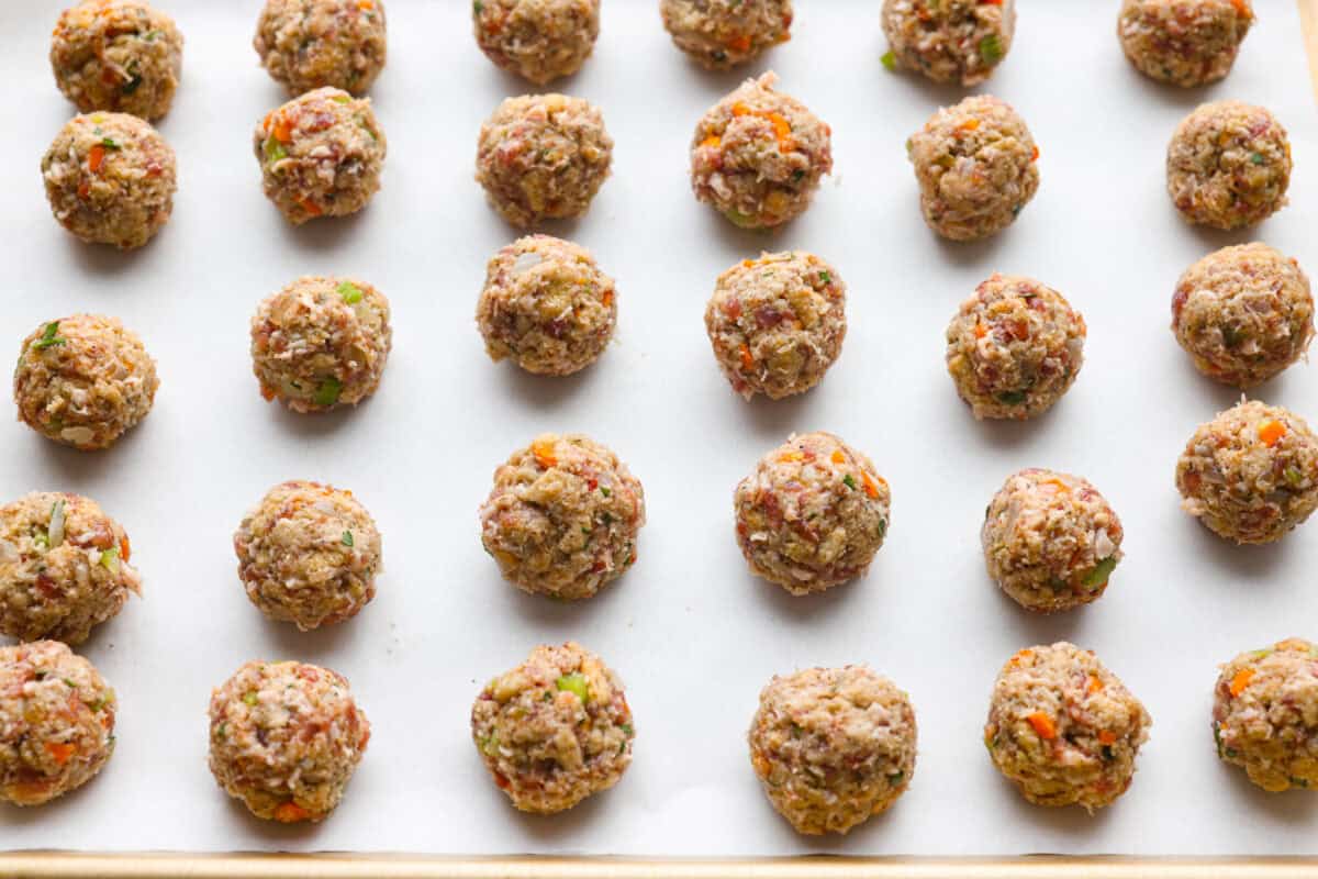 Stuffing balls ready to be baked on a baking sheet.