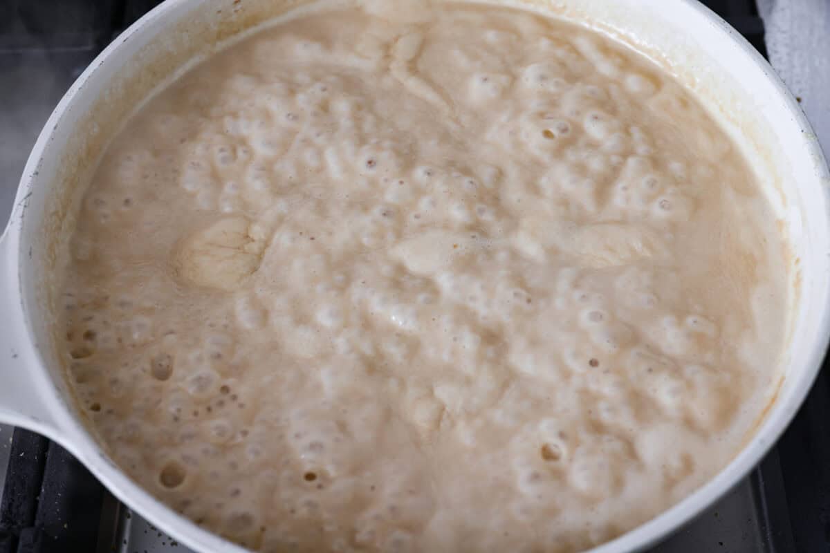 Turn those flavorful pan drippings into the creamiest gravy with a hint of tang. This sour cream gravy is rich, smooth, and so versatile. It's perfect over mashed potatoes, pork chops, but especially on my favorite Swedish Meatballs. Sauce ingredients simmering to thicken.