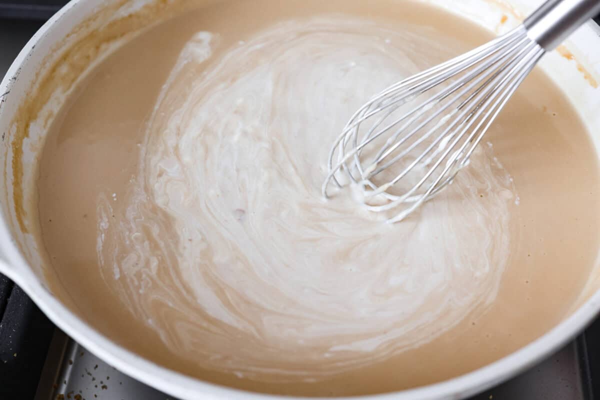 Turn those flavorful pan drippings into the creamiest gravy with a hint of tang. This sour cream gravy is rich, smooth, and so versatile. It's perfect over mashed potatoes, pork chops, but especially on my favorite Swedish Meatballs. Pan removed from heat and sour cream added to sauce and whisked in.