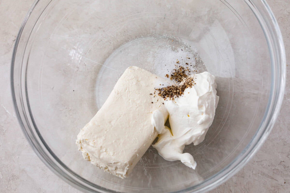 Sour cream and cream cheese added to a mixing bowl.