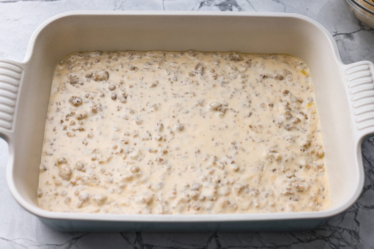 Forget the usual biscuits and gravy, this version takes everything you love and turns it into one irresistible, bubbly casserole. Creamy sausage gravy, buttery biscuits, and zero stress. Sausage gravy added to the bottom of the baking dish.