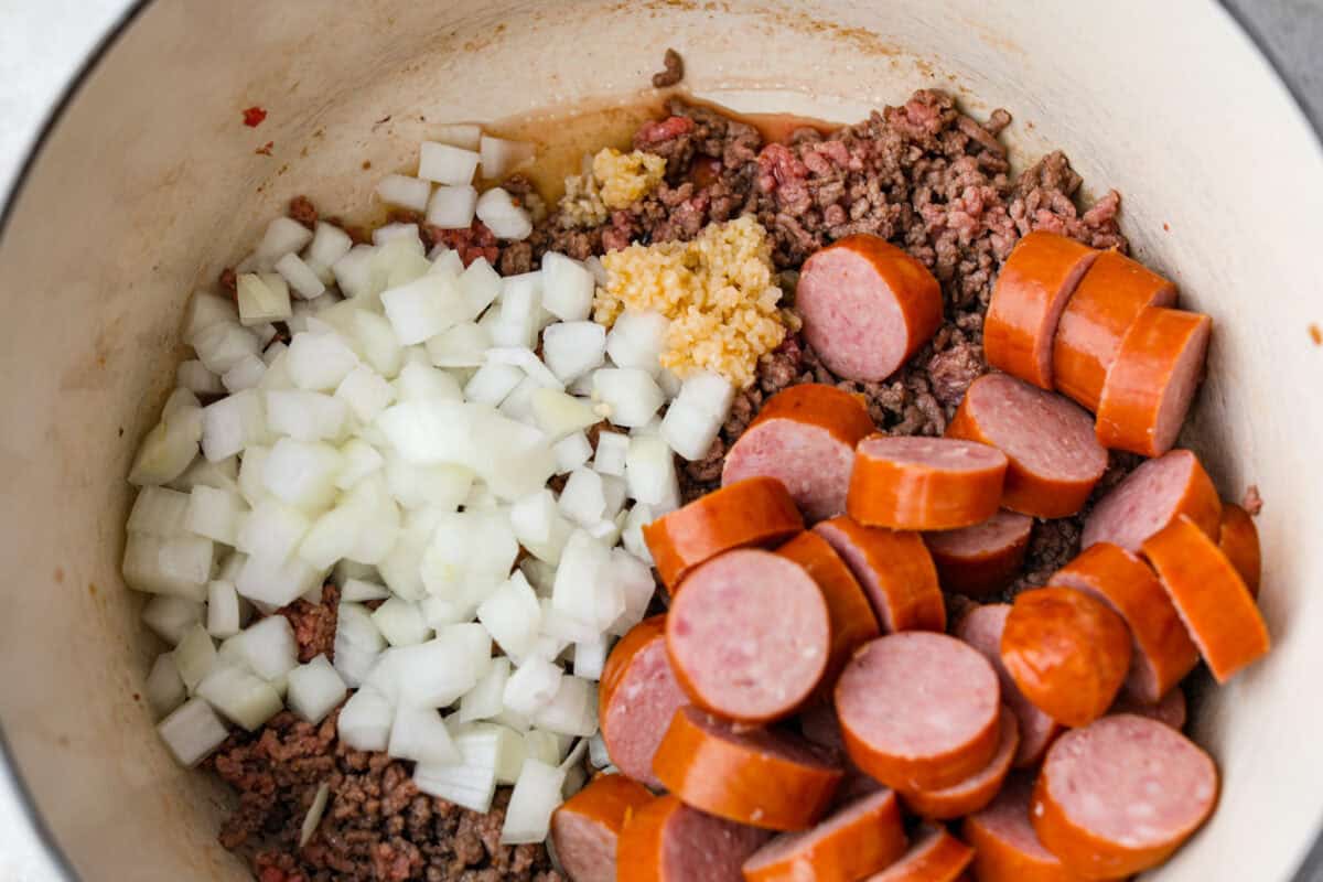 My Texas Cowboy Stew actually fills up my always-hungry boys! That's because it's loaded with smoky bacon, spicy sausage, ground beef, and potatoes. They all simmer together in a rich broth for a hearty stew. Sausage, onions, and garlic added to the cooked beef.