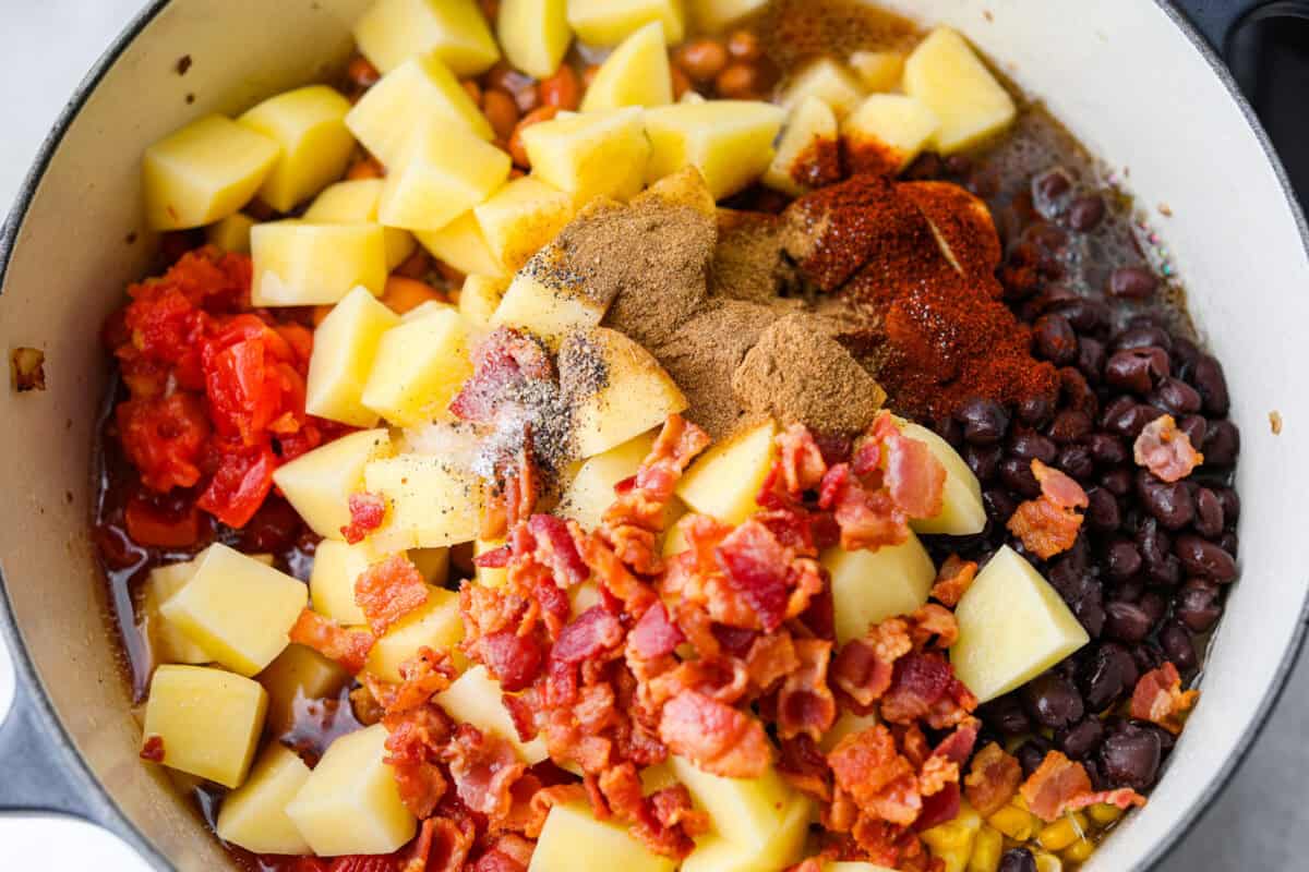 My Texas Cowboy Stew actually fills up my always-hungry boys! That's because it's loaded with smoky bacon, spicy sausage, ground beef, and potatoes. They all simmer together in a rich broth for a hearty stew. Veggies, beans, bacon, broth, and seasonings added to the cooked meat mixture.
