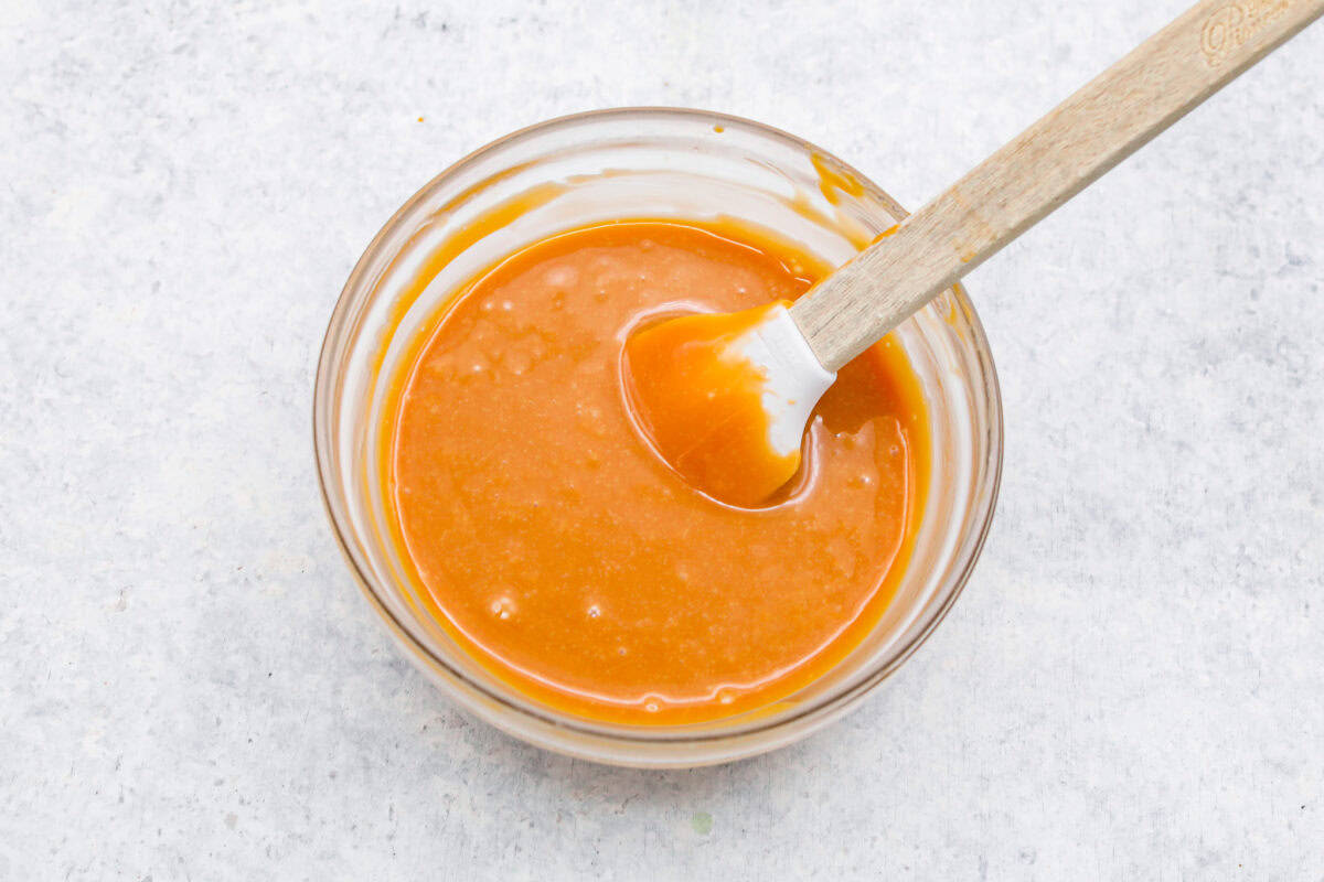 Meet the upgraded Twix thumbprint cookies! I re‑tested and updated the recipe so you'll get defined wells, clean edges, and a tender center every time! They are perfect for gift giving and cookie parties! Caramel melted in a small mixing bowl.