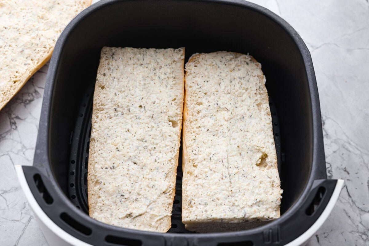 You all loved my best homemade garlic bread so much that an air fryer version was a must! It’s got the same buttery, garlicky magic, just quicker, crispier, and even easier. Garlic bread cut and placed in the air fryer basket.