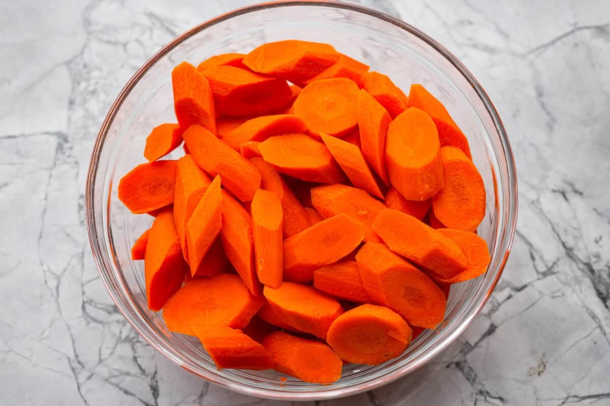 Brown Sugar glazed carrots are that sneaky-simple side that always gets rave reviews. The brown sugar caramelizes into the best buttery sweetness, and somehow everyone ends up going back for seconds. Sliced carrots in a bowl.