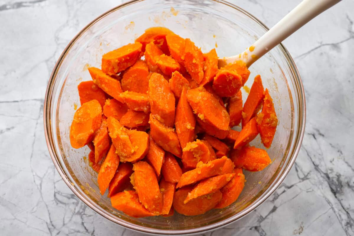Brown Sugar glazed carrots are that sneaky-simple side that always gets rave reviews. The brown sugar caramelizes into the best buttery sweetness, and somehow everyone ends up going back for seconds. Someone stirring the sliced carrots with the glaze.