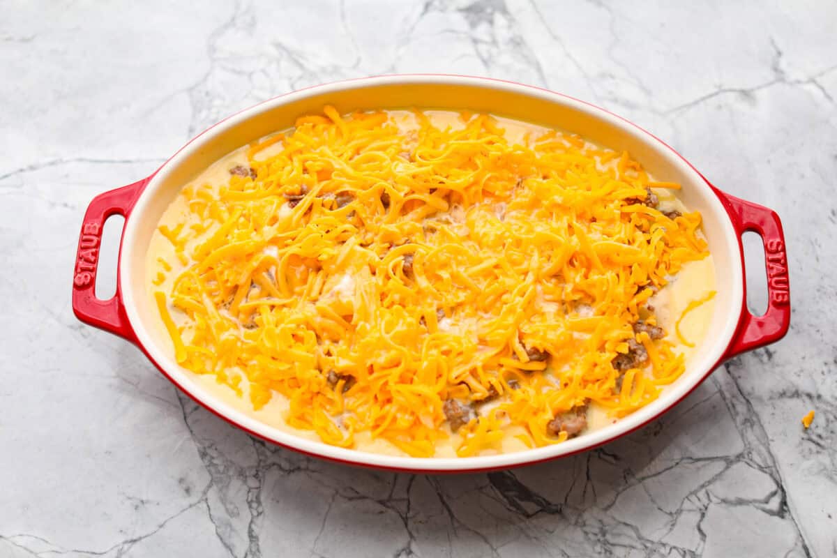 Wake up to a breakfast that feels like a warm hug! This Christmas morning casserole turns sausage, eggs, cheese, and fluffy biscuits into the easiest, hearty breakfast you can't get enough of! Egg mixture poured over the top of the Christmas breakfast casserole.