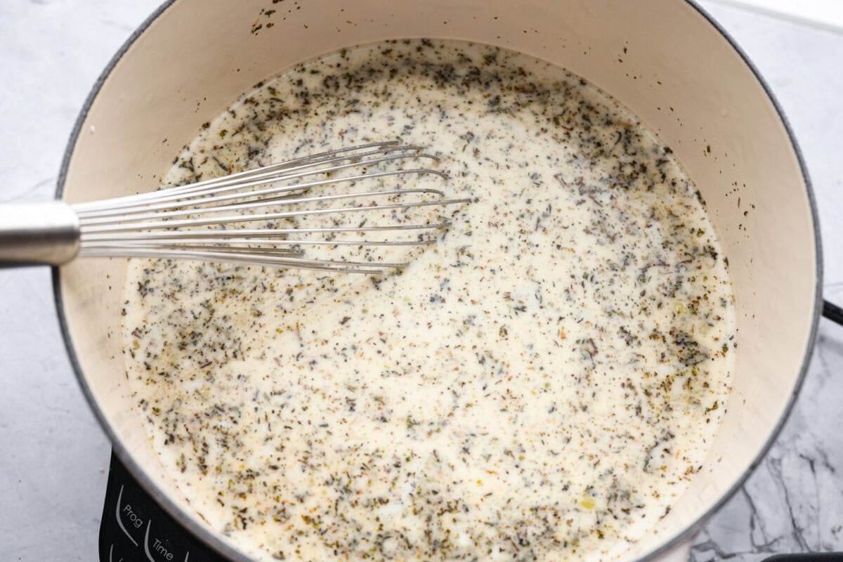 Warm up fast with this creamy, cheesy chicken Alfredo soup! Tender chicken, rich broth, and pasta all come together in just 30 minutes for the ultimate comfort bowl. Seasonings, chicken broth, and half and half added to the pot.