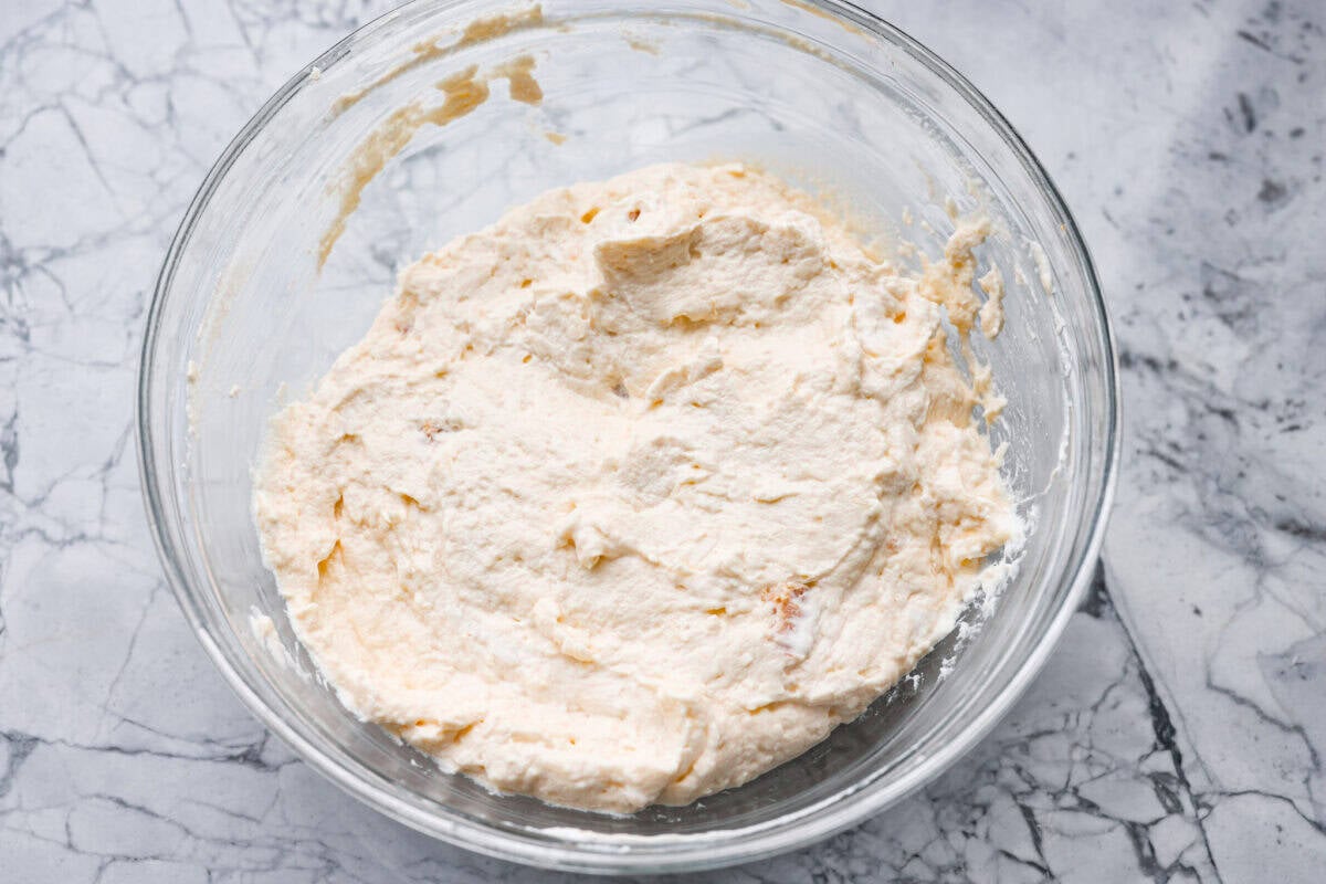 Sour cream and cream of chicken soup mixed together in a mixing bowl. 