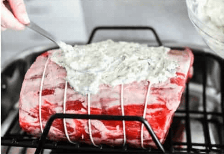 I have the perfect fool proof prime rib recipe for you. I have done all of the testing for you so that you can achieve the perfect prime rib every single time. Melt in your mouth, cooked perfectly to medium rare with a perfect garlic butter crust, this recipe is incredible. I will help you feel confident every step of the way! Someone spreading the garlic herb butter on top of the prime rib roast.