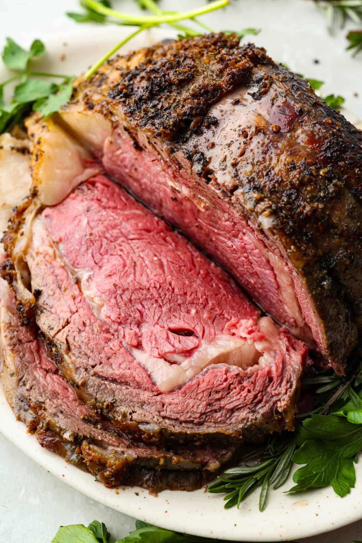 I have the perfect fool proof prime rib recipe for you. I have done all of the testing for you so that you can achieve the perfect prime rib every single time. Melt in your mouth, cooked perfectly to medium rare with a perfect garlic butter crust, this recipe is incredible. I will help you feel confident every step of the way! Perfectly cooked medium rare prime rib roast sliced down the middle.