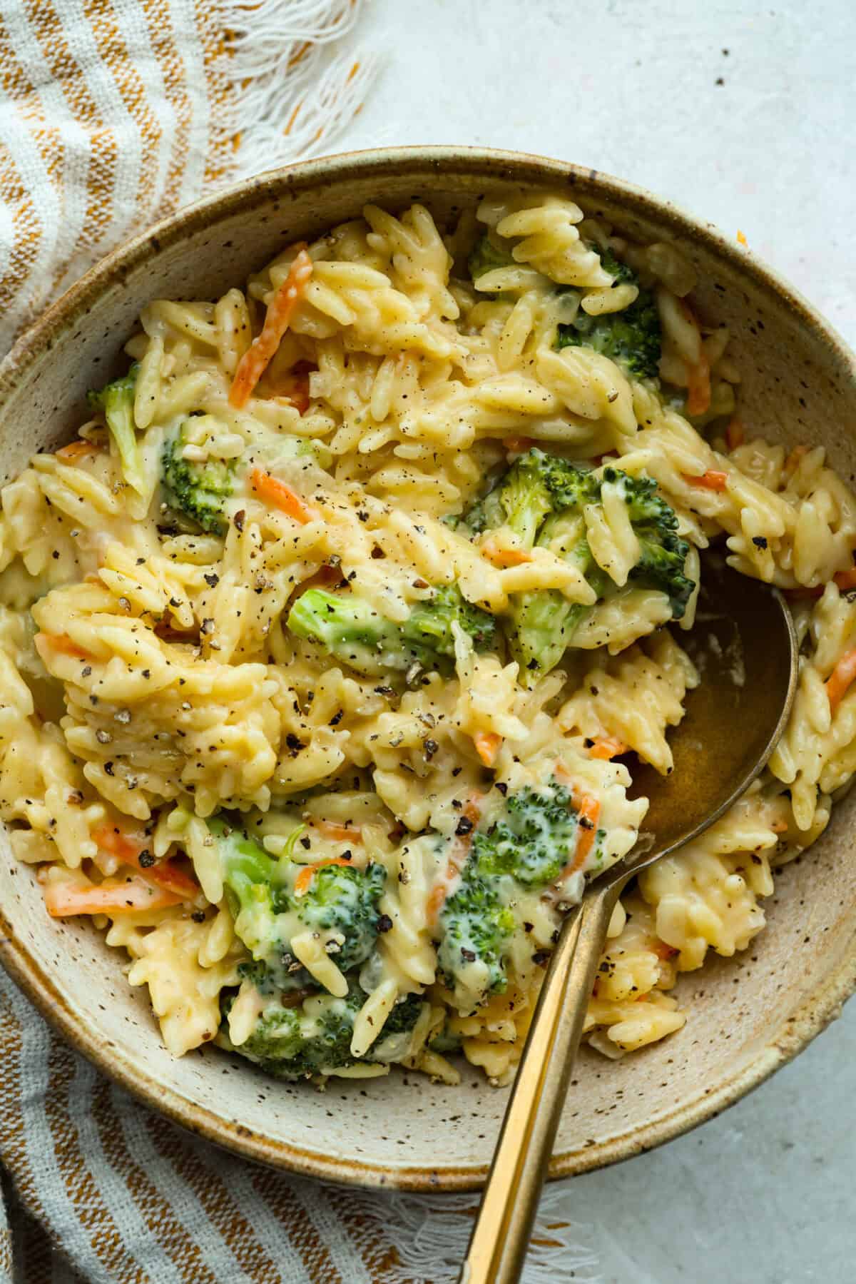 Broccoli cheddar orzo serving in a dish. 