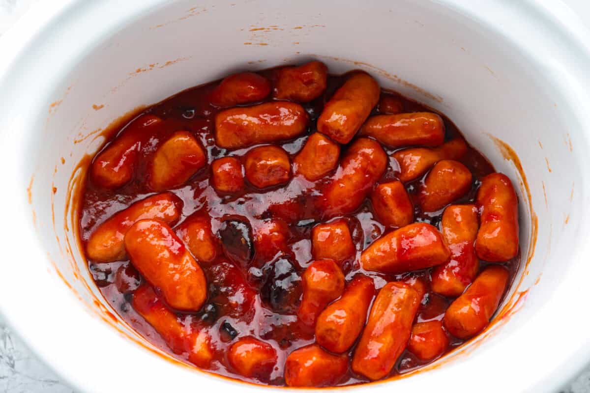 If you’re hosting anything and need a quick appetizer, these crockpot grape jelly little smokies are it. Dump everything in the slow cooker, walk away, and come back to glossy, flavorful sausages that people hover around all night. Everything mixed together ready to cook.
