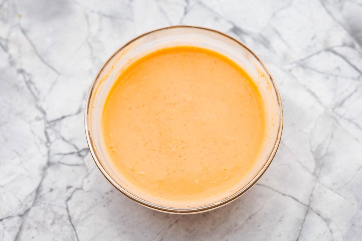 Bang bang shrimp pasta is what weeknight dinner dreams are made of! Juicy shrimp, tender pasta, and that irresistible sweet-and-spicy bang bang sauce come together in just 20 minutes. It’s creamy, bold, and guaranteed to be a hit. Mixing bowl full of sauce ingredients all mixed together.