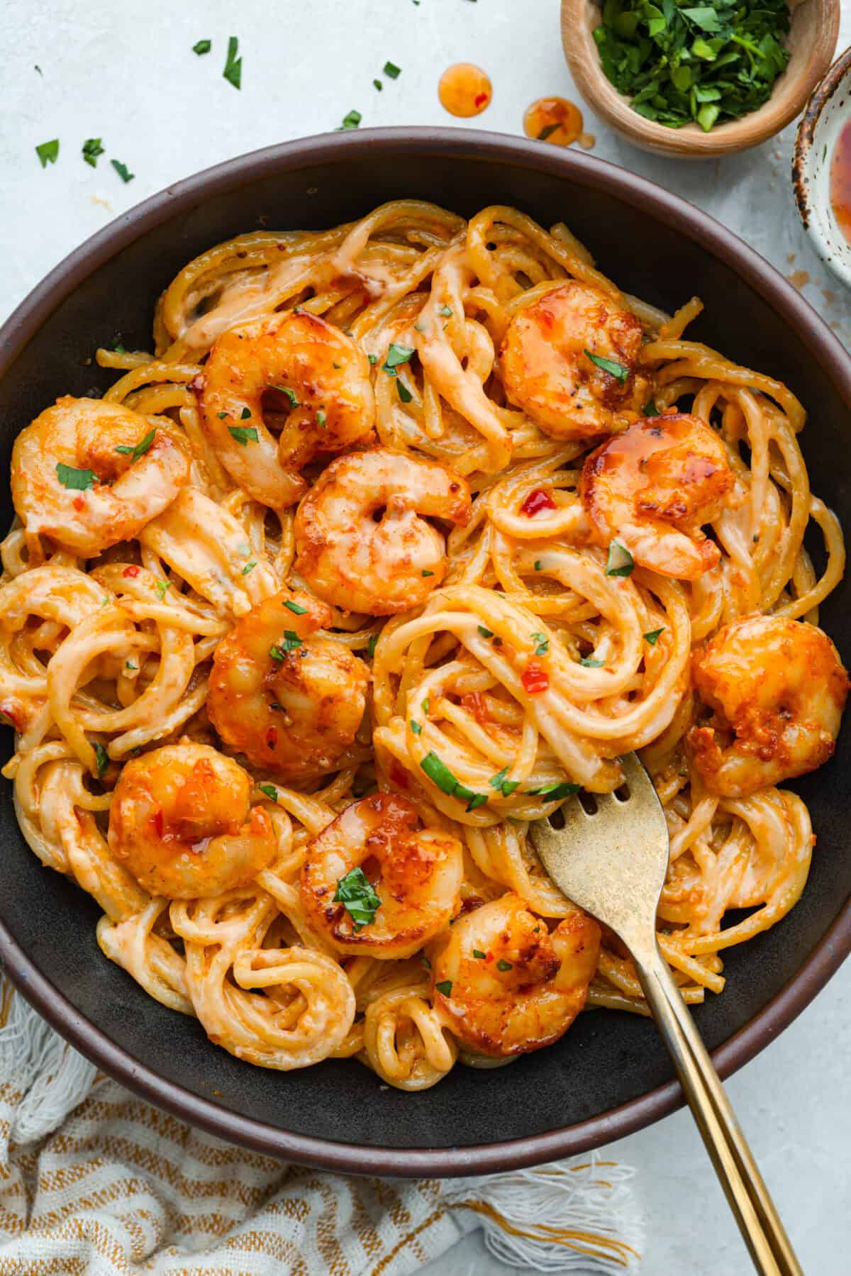 Bang bang shrimp pasta is what weeknight dinner dreams are made of! Juicy shrimp, tender pasta, and that irresistible sweet-and-spicy bang bang sauce come together in just 20 minutes. It’s creamy, bold, and guaranteed to be a hit. Plated bang bang shrimp pasta with gold spoon.