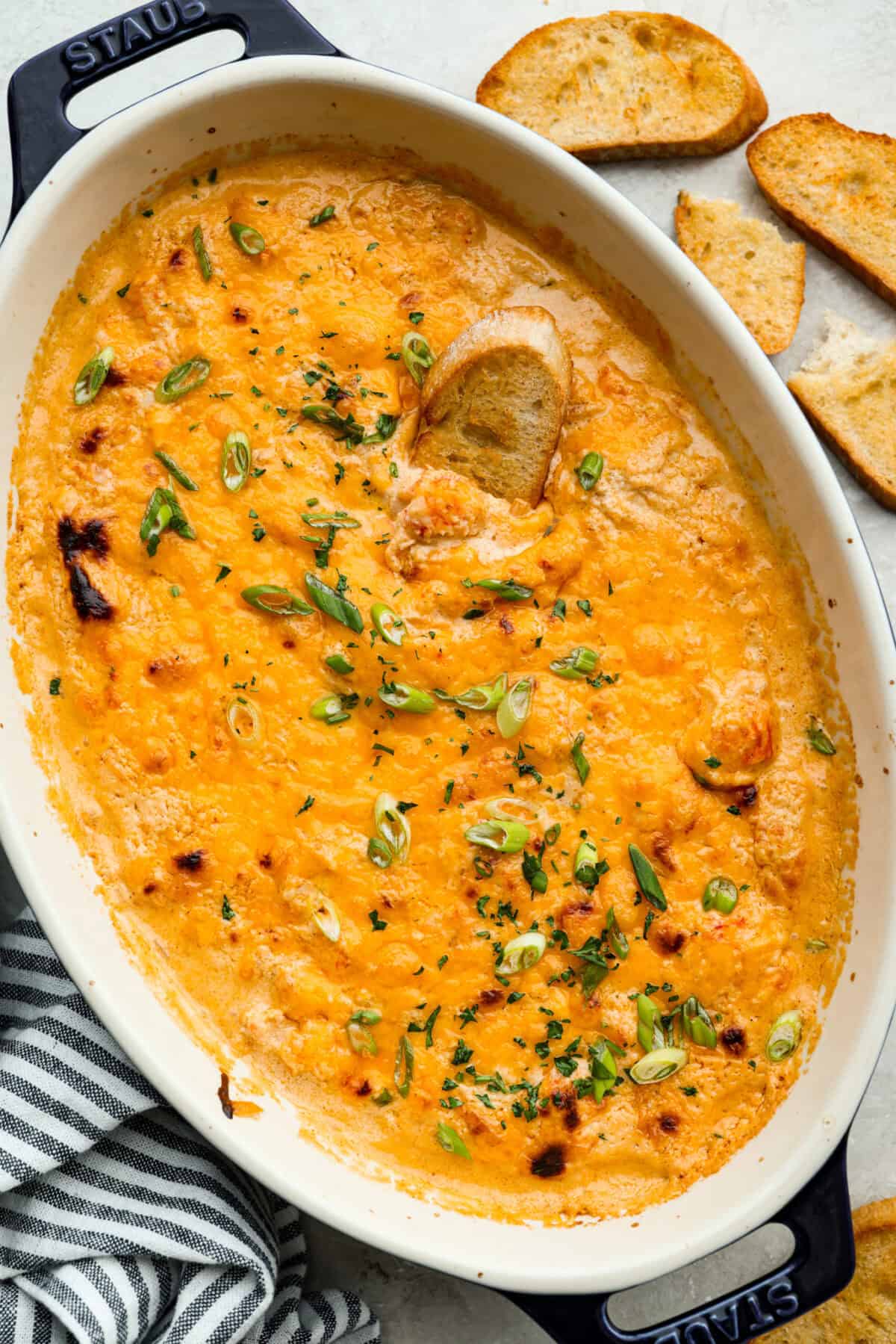 Top down shot of the lobster roll dip all baked, and cheesy and perfect!