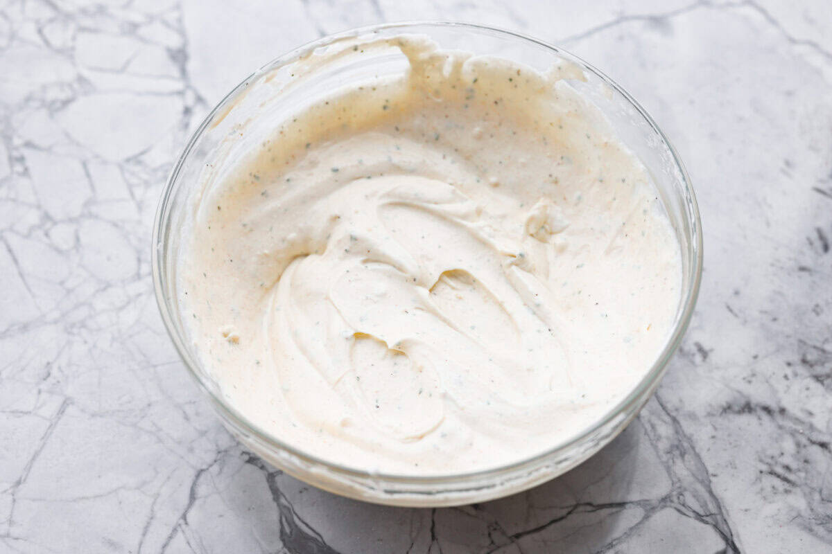 Sour cream and mayonnaise mixed together with the ranch seasoning in a mixing bowl. 