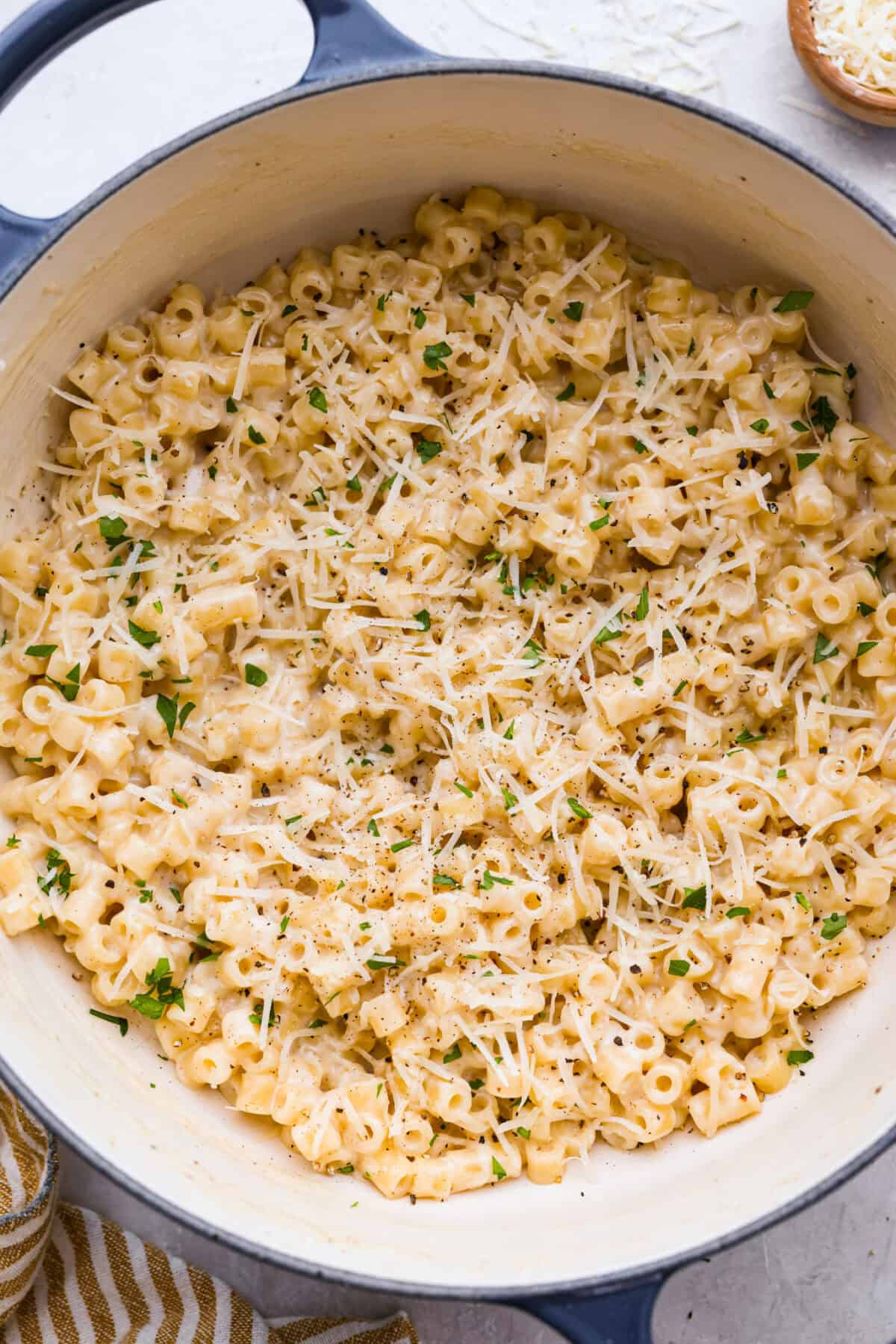 Overhead shot of the pan of Ditalini pasta with cheese and parsley added to the top. 