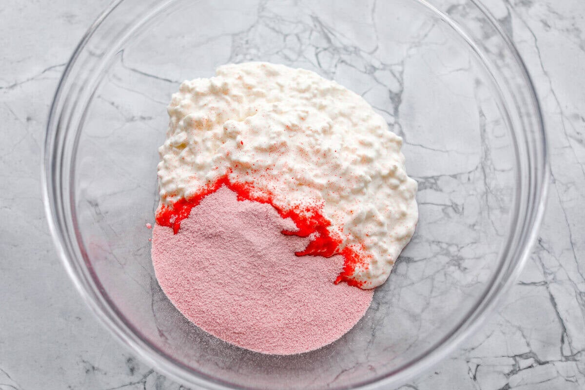 This cottage cheese jello salad is one of those old-school recipes that never really goes out of style. My dad absolutely loves it and requests it all the time, especially for family get-togethers. It’s creamy, fruity, and ridiculously easy to make. Cottage cheese and Jello packet dumped in a large bowl.