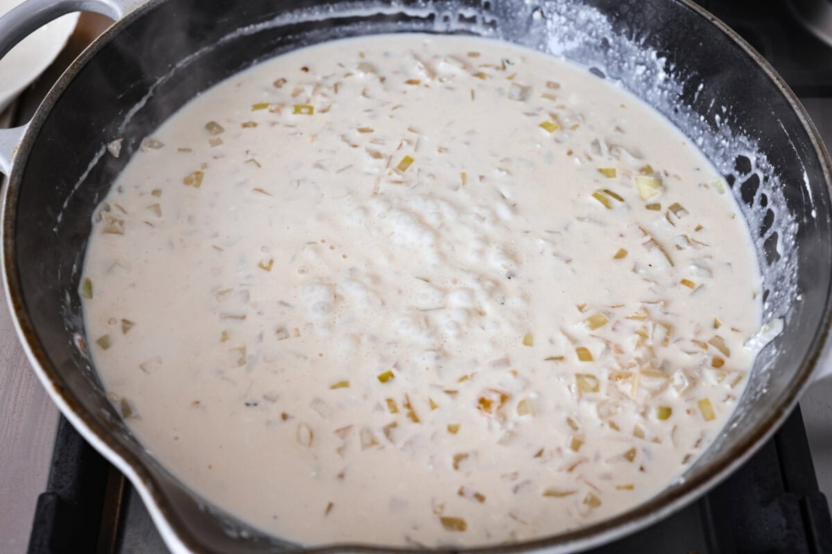 Groceries are expensive right now, so I’ve been leaning hard on the cheap staples. This melting cabbage with a garlicky cream sauce, sun-dried tomatoes, and Parmesan is easy, budget friendly, and tastes amazing. Broth added to the pan and cream cheese added to that and melted to start the sauce.