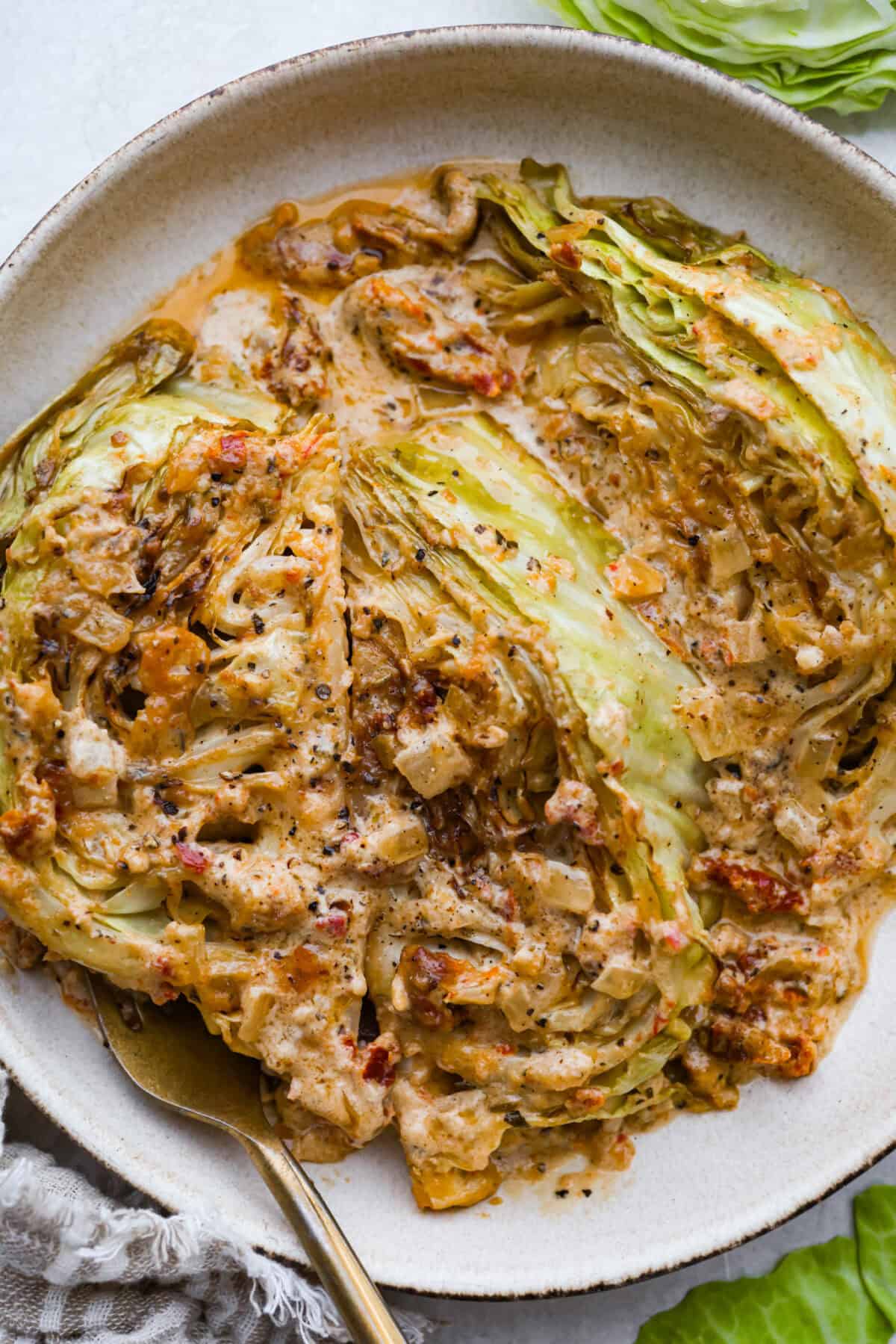 Groceries are expensive right now, so I’ve been leaning hard on the cheap staples. This melting cabbage with a garlicky cream sauce, sun-dried tomatoes, and Parmesan is easy, budget friendly, and tastes amazing. Plated tuscan melting cabbage ready to be eaten.