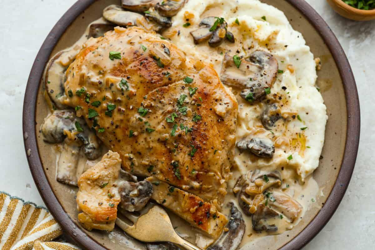 This chicken Diane takes everything you love about steak Diane and turns it into an easy chicken dinner. One skillet, a rich creamy mushroom sauce, and tons of flavor in every bite! Plated chicken Diane with mashed potatoes.