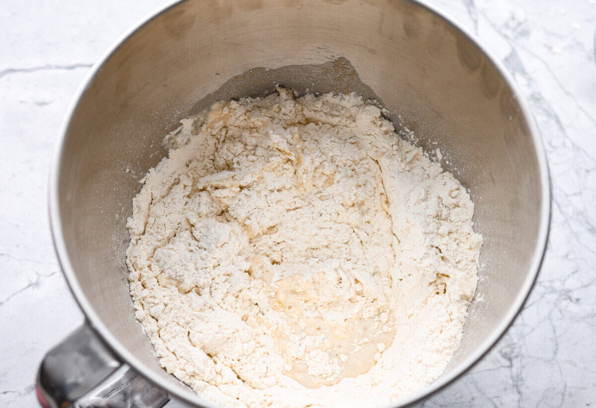 Warm water, yeast, sugar oil, salt, and flour all added to the bowl of a stand mixer. 