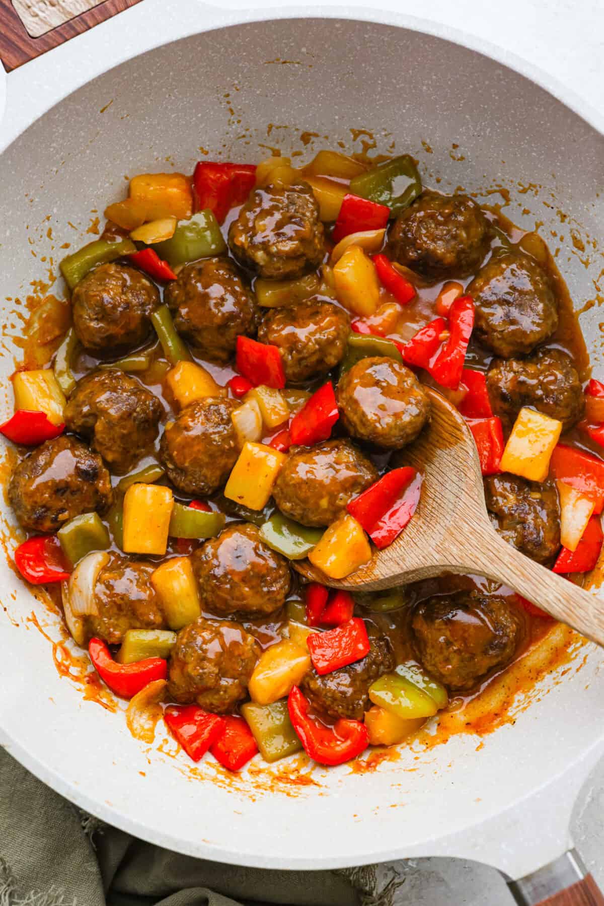 These sweet and sour meatballs are one of those dinners I pull out when I need something easy, but I know everyone likes! They’re saucy, a little sweet, a little tangy, and come together fast. Skillet with sweet and sour meatballs cooking in it with the pineapple and veggies.